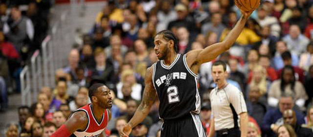 San Antonio Spurs forward Kawhi Leonard (2) holds the ball against Washington Wizards guard John Wall (2) during the first half of an NBA basketball game, Saturday, Nov. 26, 2016, in Washington.